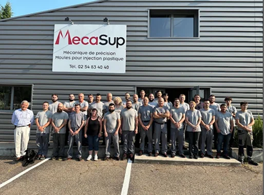 Équipe d'employés et leur chien posant devant le bâtiment MecaSup à Salbris dans le Loir-et-Cher 41