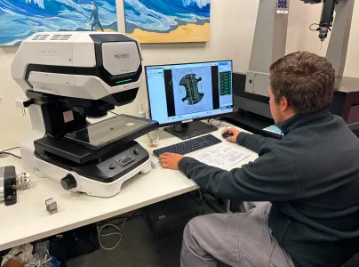Homme utilisant un microscope numérique et un ordinateur pour l'inspection de précision de pièces à Salbris dans le Loir-et-Cher 41