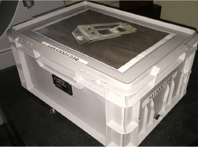 Conteneur blanc translucide avec un composant métallique à l'intérieur, sur une surface foncée à Salbris dans le Loir-et-Cher 41